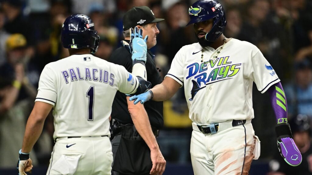 Yandy Díaz and Richie Palacios exchange a hand slap during ALCS Game 6 at Tropicana Field.