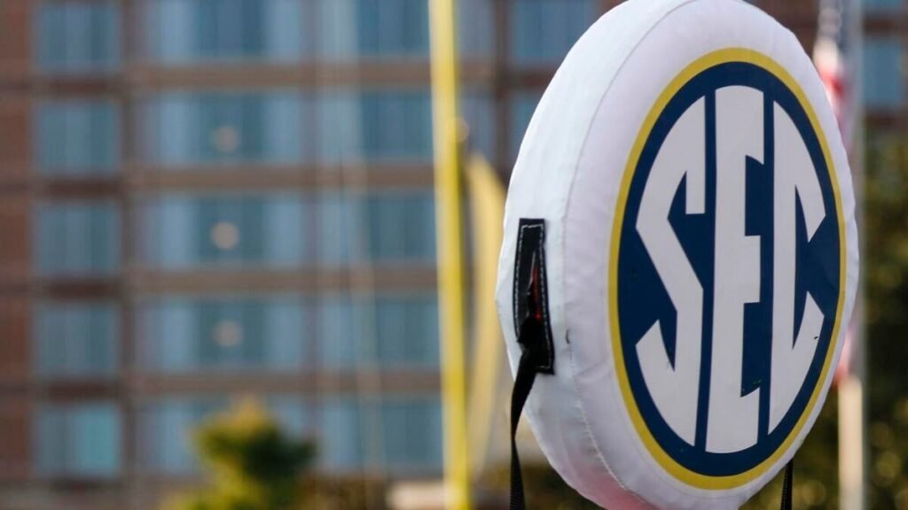 An SEC logo on football field equipment beside a goalpost.