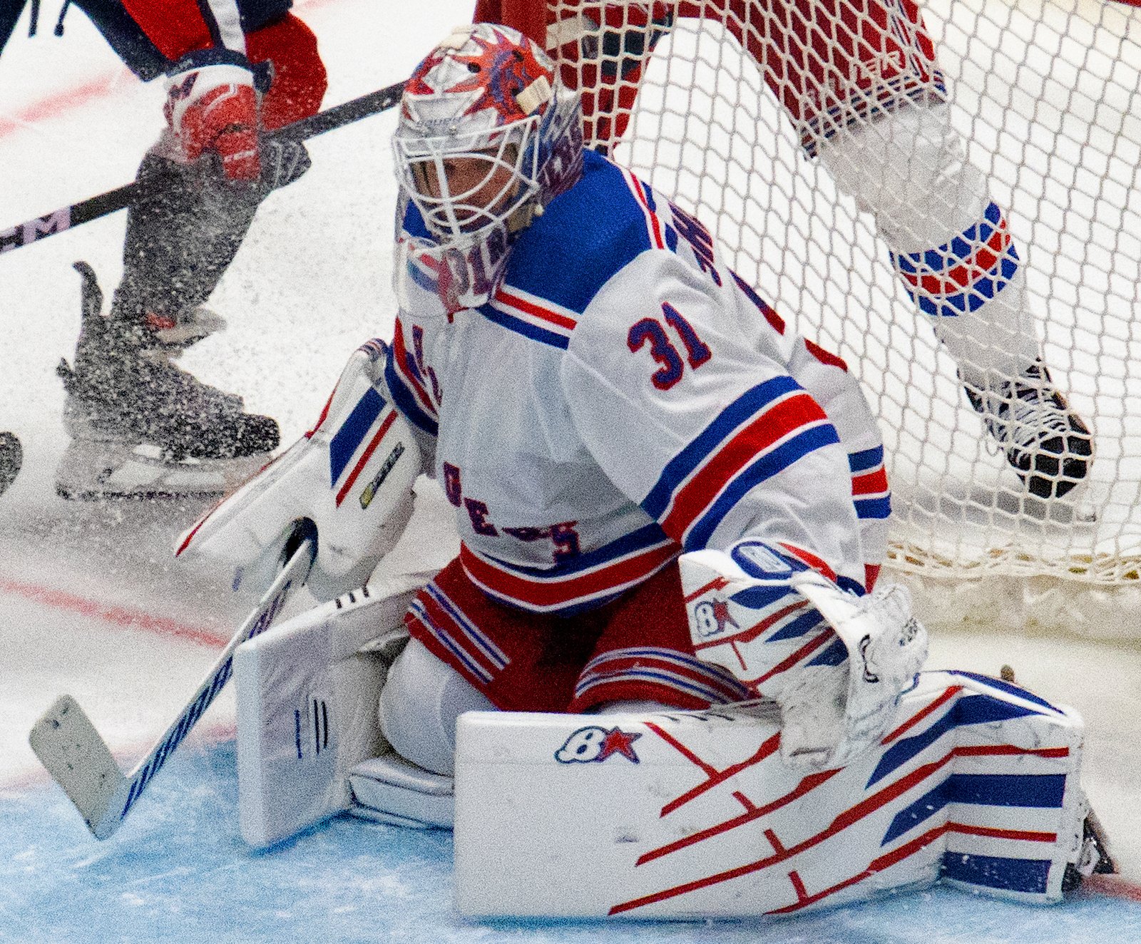 Igor Shesterkin crouches in the Rangers crease with his glove and stick ready.