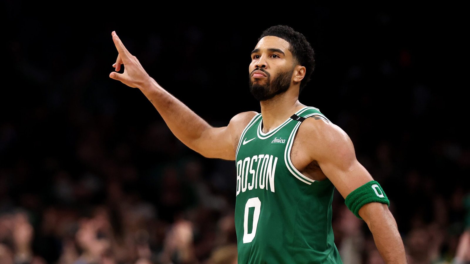 Jayson Tatum gestures on court in a Celtics uniform.