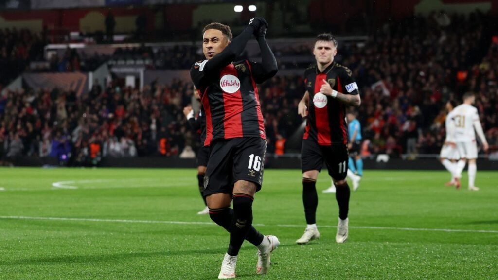 A Bournemouth player applauds on the pitch with teammates and AC Milan players nearby.