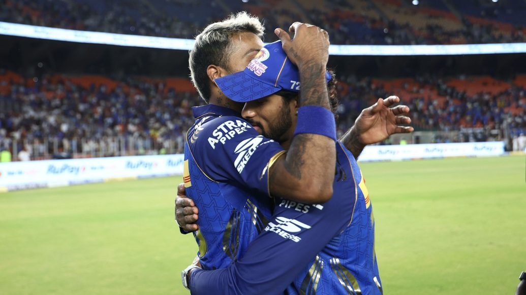 Tilak Varma, wearing a cap, embraces a Mumbai Indians teammate after their April 20, 2026, match in Ahmedabad.
