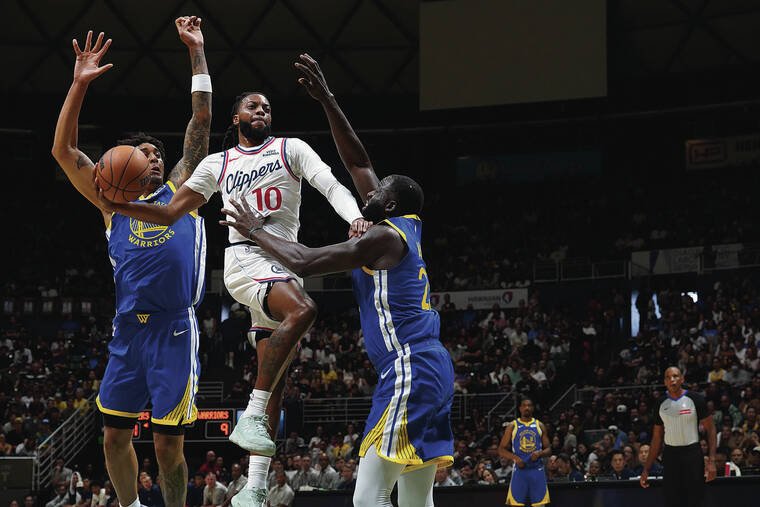 Clippers guard Bradley Beal drives between Golden State defenders in Honolulu.