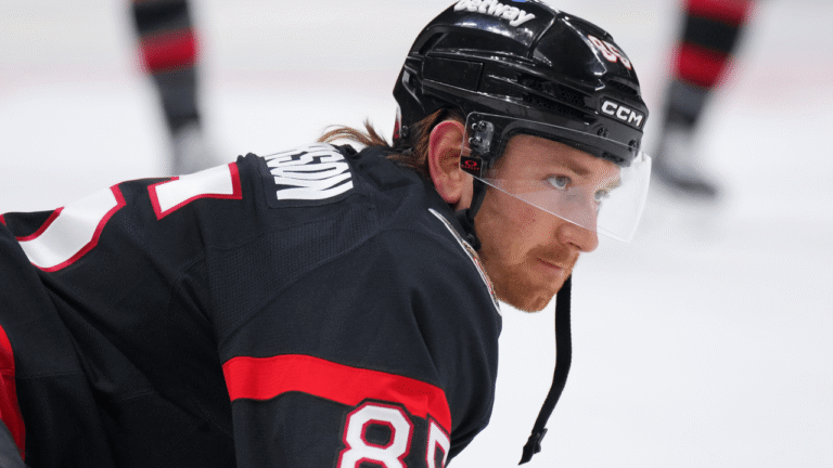 Jake Sanderson in a black Ottawa Senators jersey and helmet.