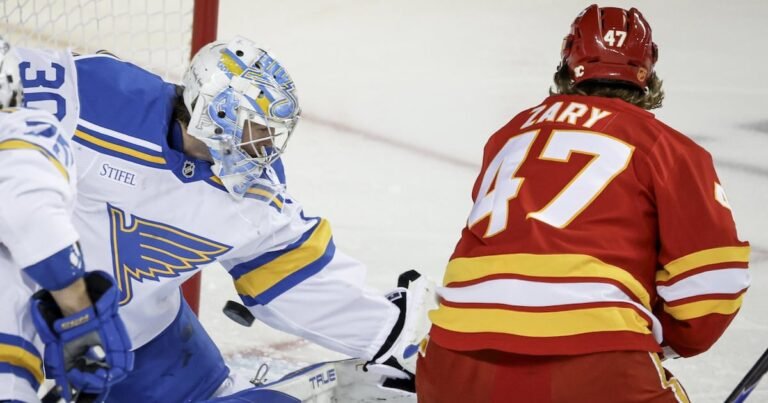 Calgary’s Connor Zary faces St. Louis goalie Joel Hofer near the net.