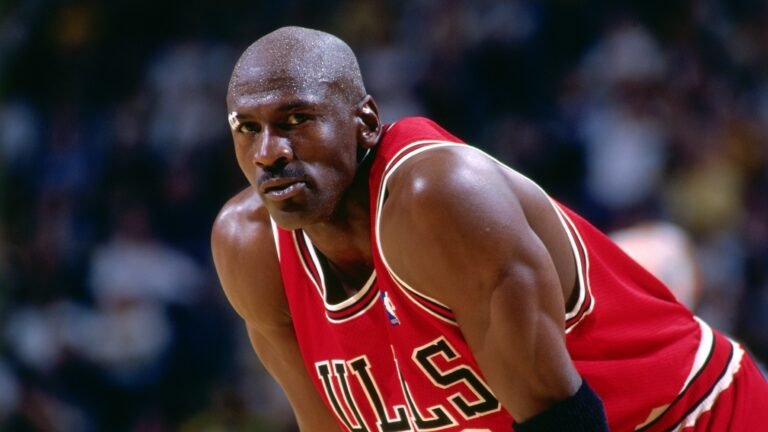 Michael Jordan wearing a red Chicago Bulls jersey.