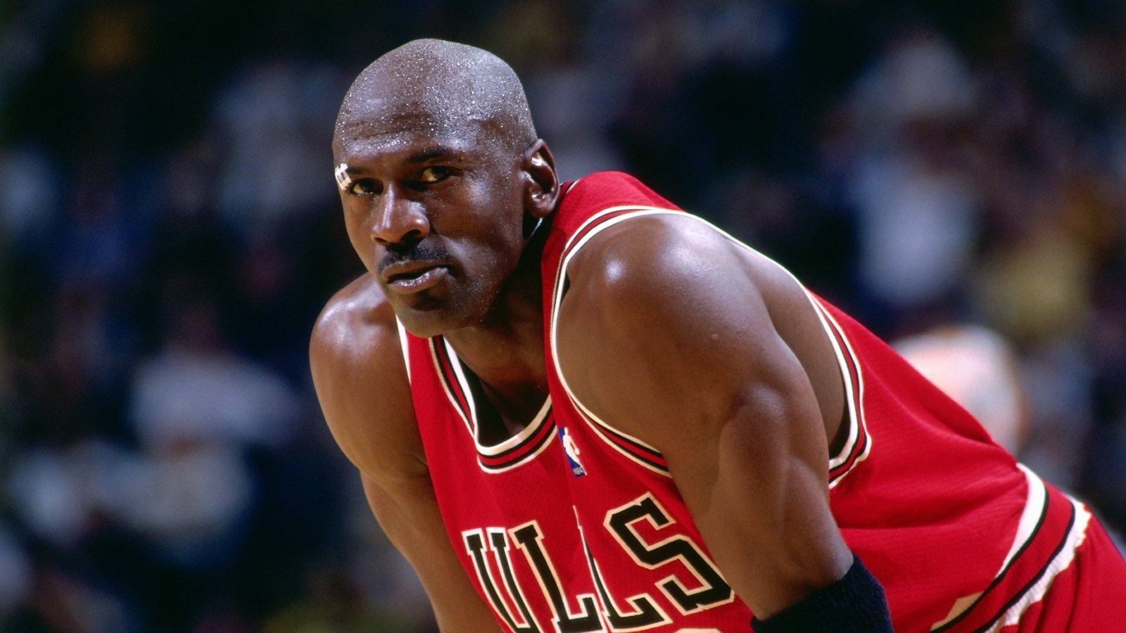 Michael Jordan wearing a red Chicago Bulls jersey.