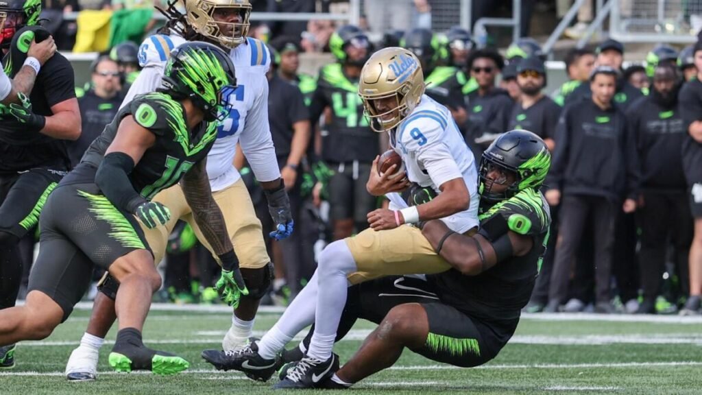 Nico Iamaleava is tackled by Oregon defenders.