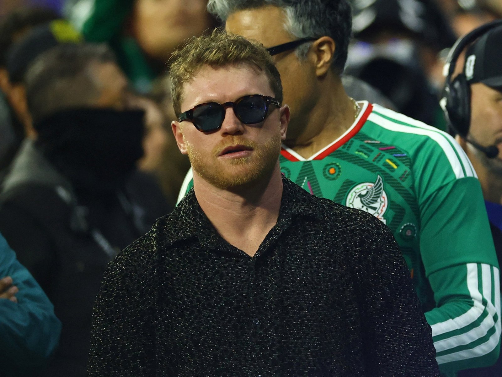 Canelo Alvarez wearing sunglasses among spectators at a football match