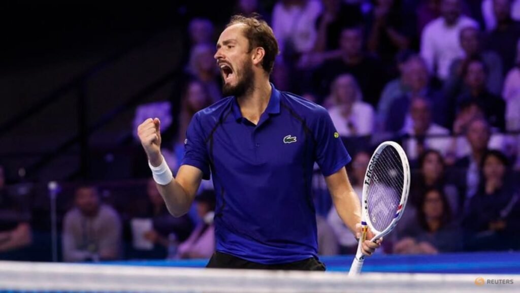 Daniil Medvedev clenches a fist while holding his racket on an indoor court.