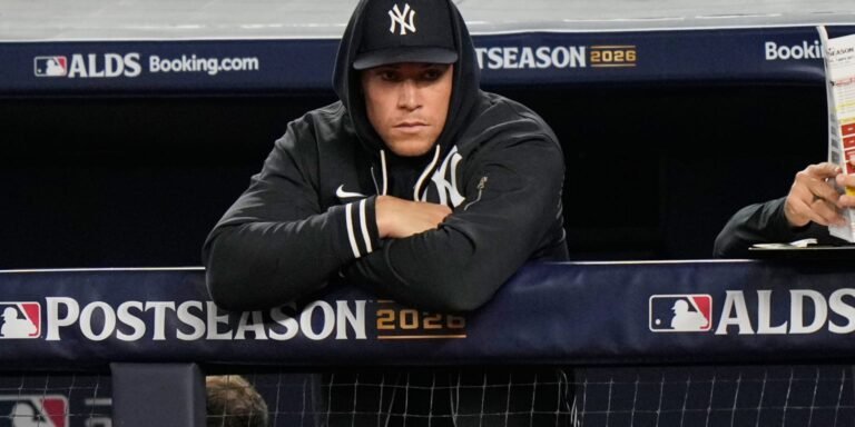 Aaron Judge leaning on the Yankees dugout railing during the 2026 postseason.