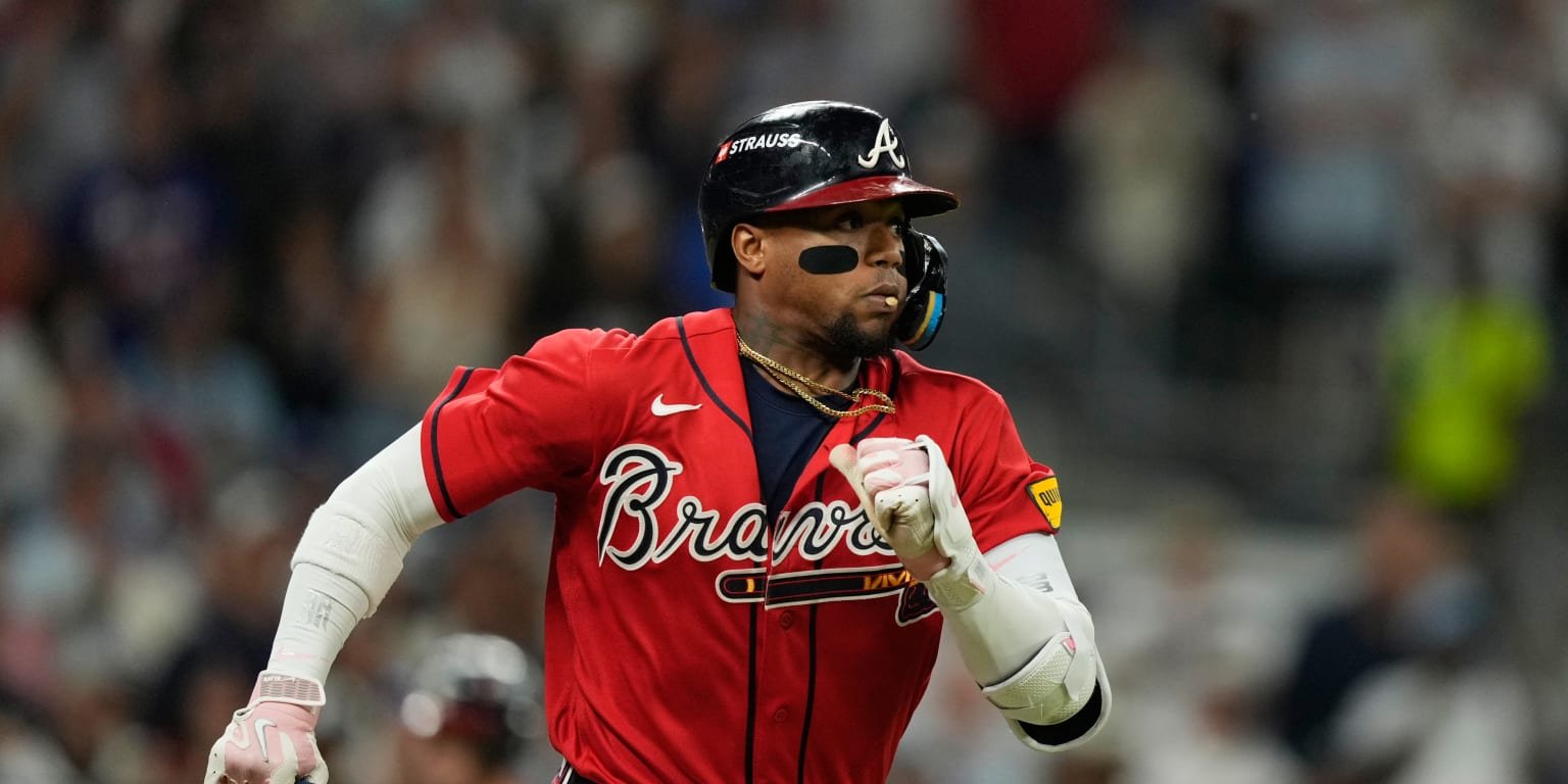 Ronald Acuña Jr. running in a red Atlanta Braves uniform and batting helmet.
