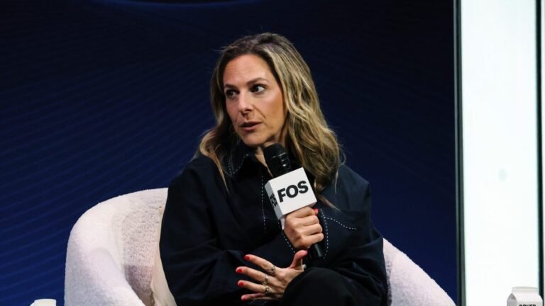 Jessica Berman holds a Front Office Sports microphone while speaking onstage at the Tuned In summit.