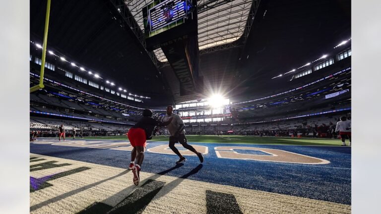 Buccaneers players warming up in the Cowboys end zone at AT&T Stadium.