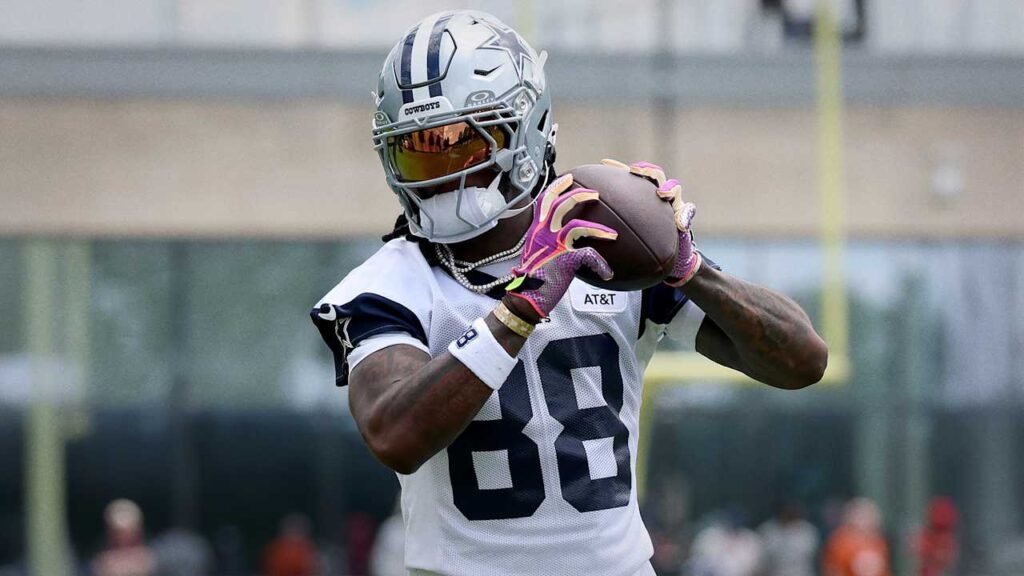 CeeDee Lamb holds a football during Cowboys practice.