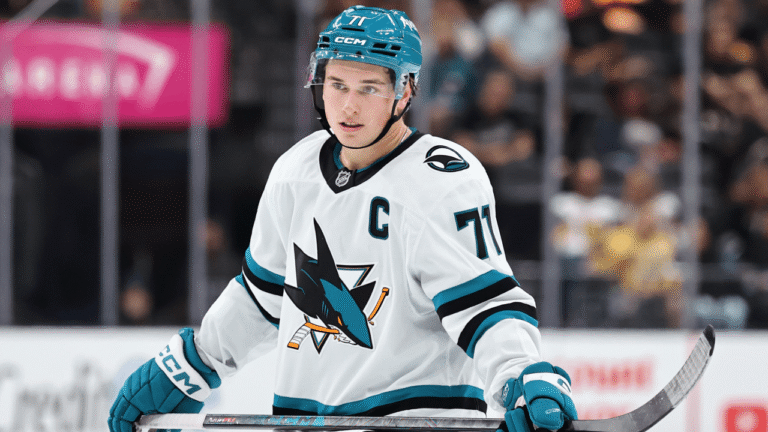 Macklin Celebrini in a white San Jose Sharks jersey and teal helmet