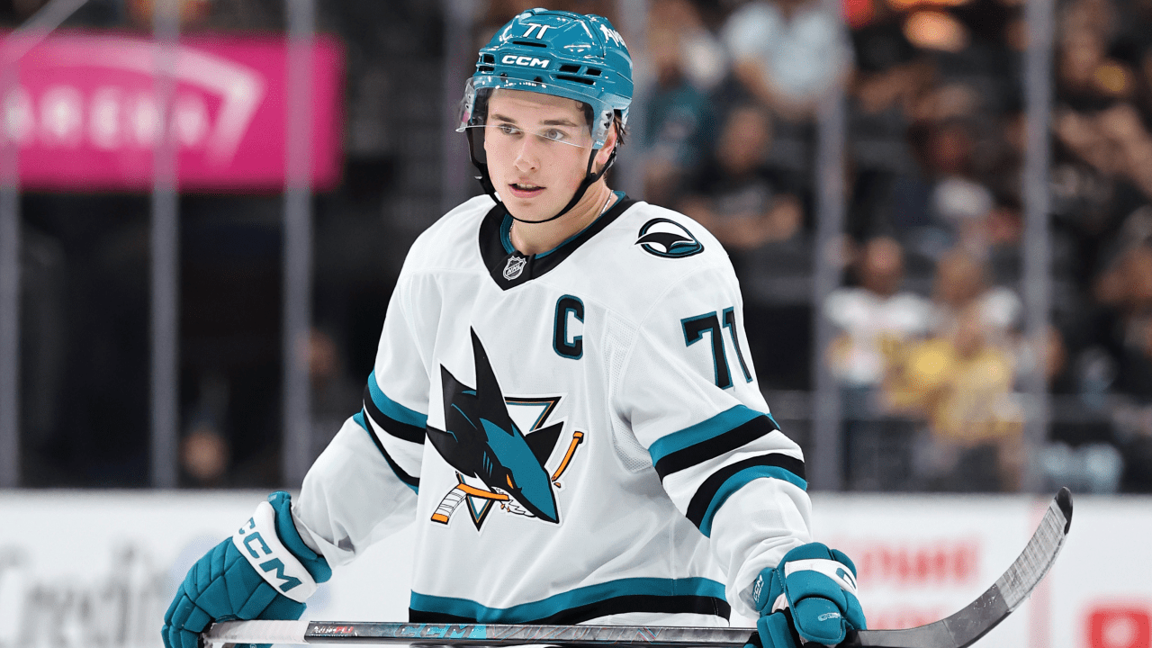 Macklin Celebrini in a white San Jose Sharks jersey and teal helmet