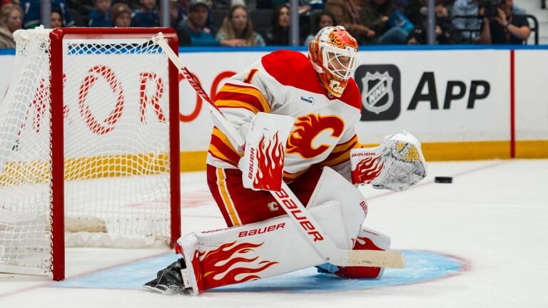 Devin Cooley guarding the Calgary Flames net in a white uniform