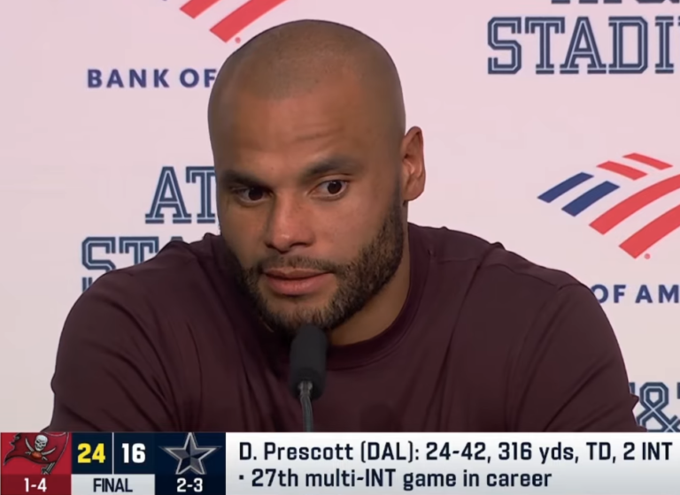 Dak Prescott at a microphone, with a graphic showing Tampa Bay’s 24–16 final score against Dallas.