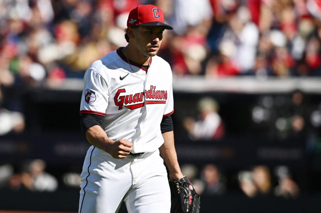 Guardians pitcher Daniel Espino clenches his fist while wearing Cleveland’s white uniform and red cap.