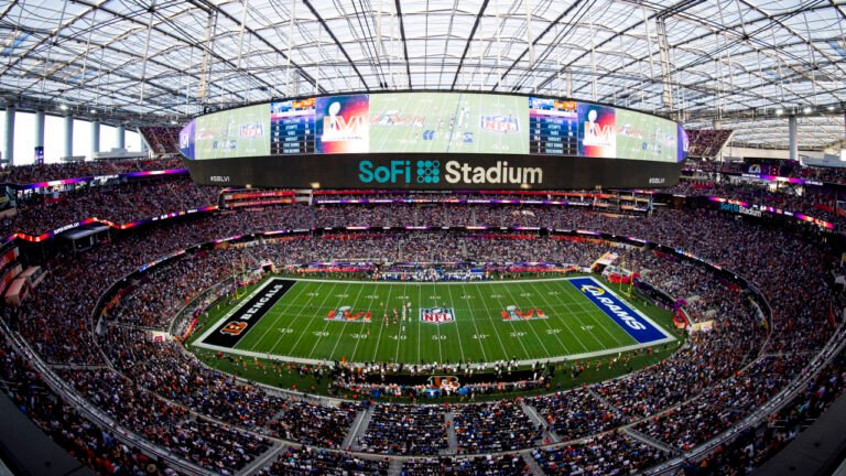 A wide interior view of SoFi Stadium with spectators surrounding the football field.