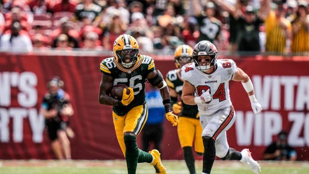Edgerrin Cooper runs with the football with a Tampa Bay player behind him.