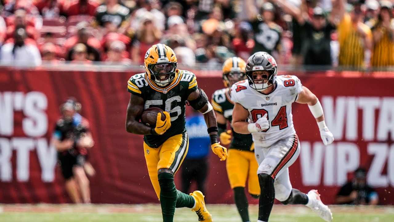 Edgerrin Cooper runs with the football with a Tampa Bay player behind him.