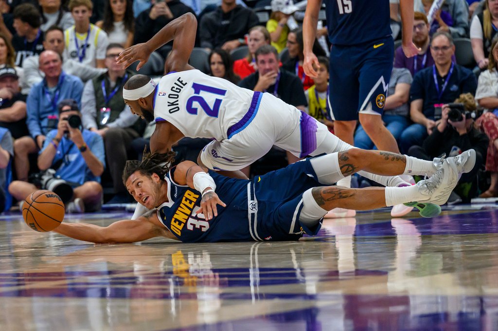 Aaron Gordon reaches for a loose basketball as Utah guard Josh Okogie dives over him.