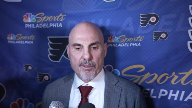 Rick Tocchet stands in front of a Flyers and NBC Sports Philadelphia interview backdrop.
