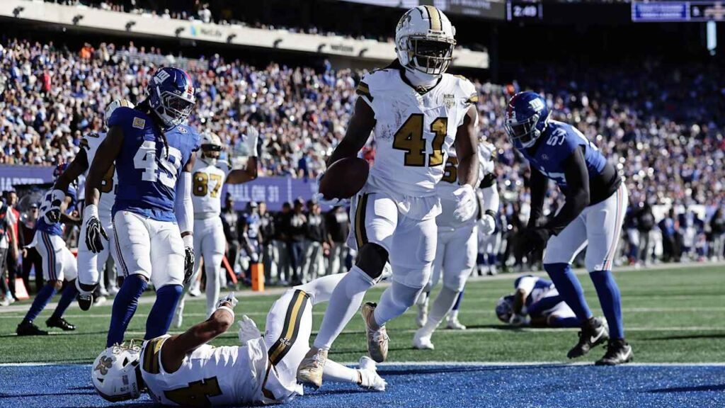 Saints running back Alvin Kamara carries the ball against Giants defenders.