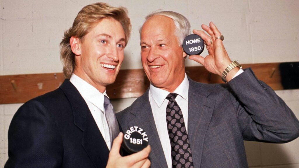 Wayne Gretzky and Gordie Howe hold pucks marked with their NHL points totals, 1851 and 1850.