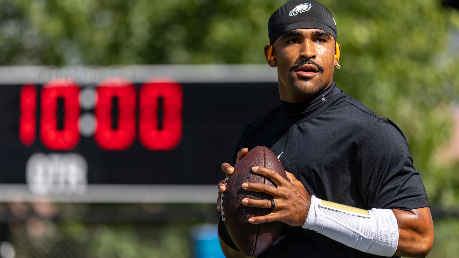 Jalen Hurts holds a football at Eagles practice.