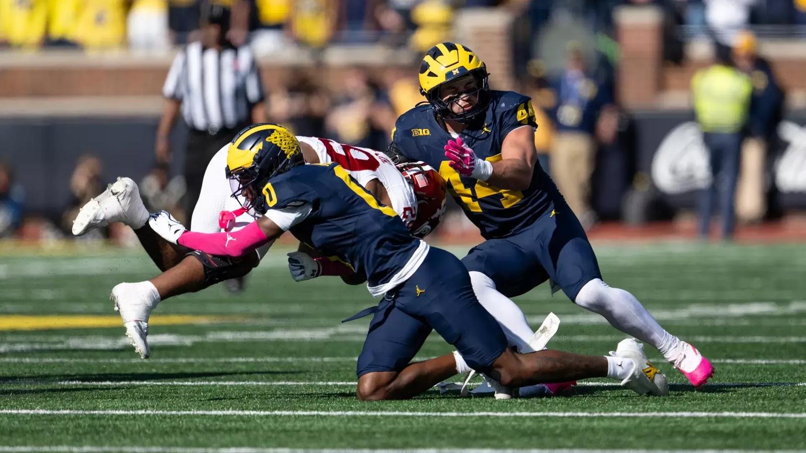 Michigan defenders tackle an Indiana runner.