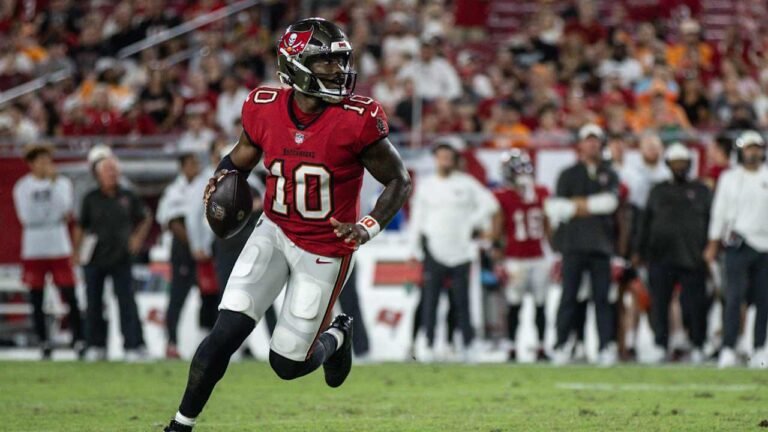 Jalon Daniels runs with the football in a red Tampa Bay Buccaneers No. 10 uniform.
