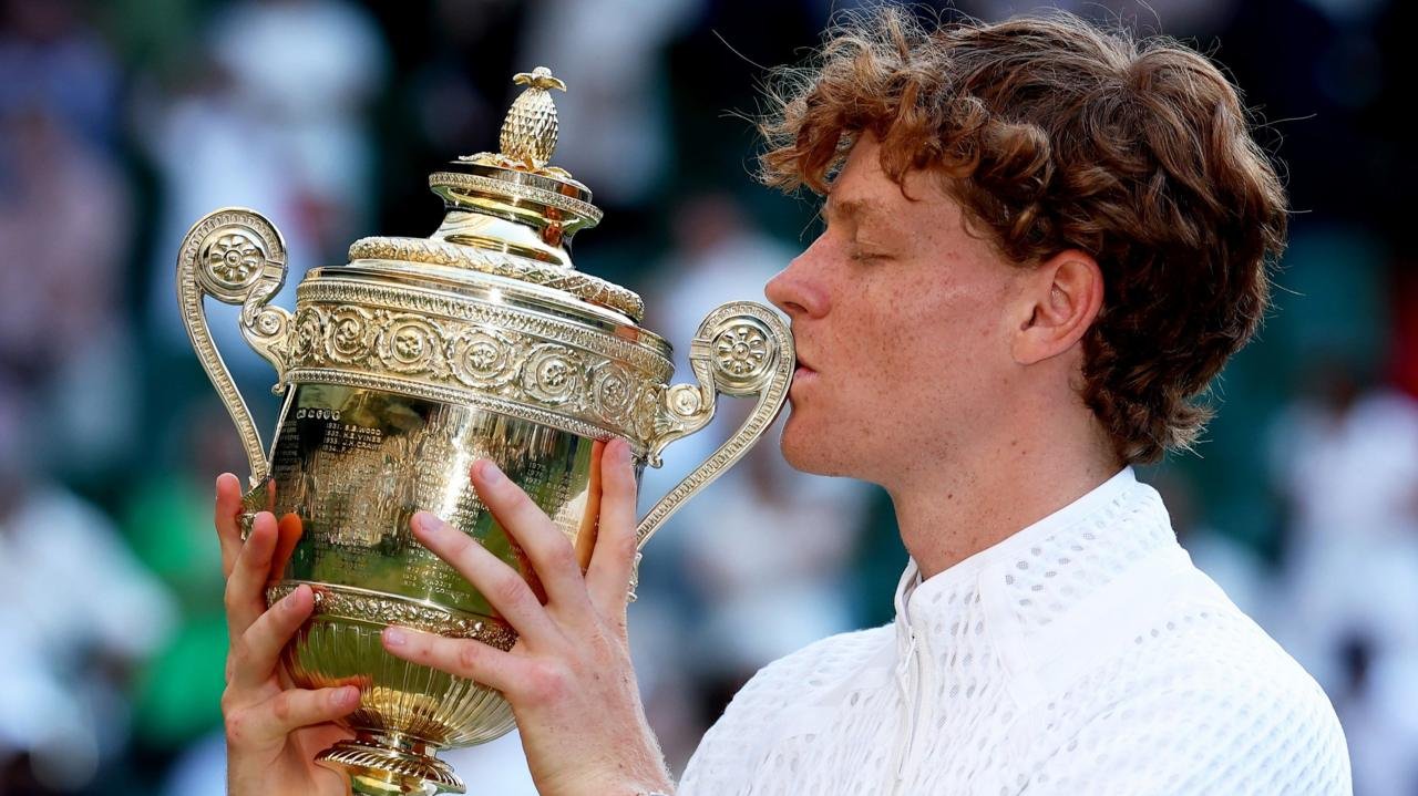 Jannik Sinner kisses the Wimbledon men's singles trophy.