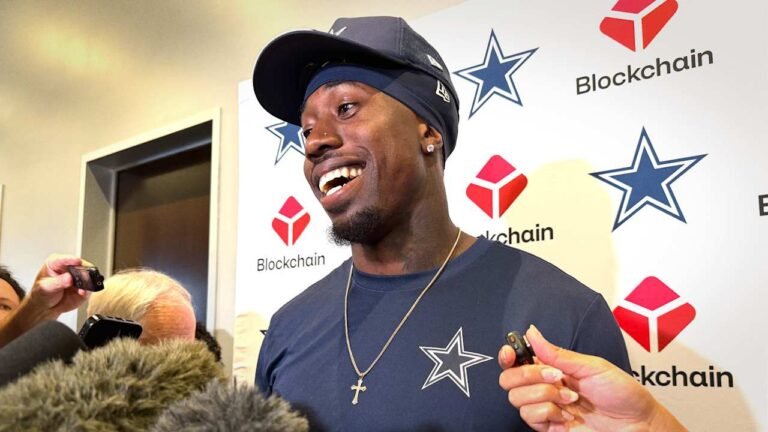 Joey Porter Jr smiles while speaking with reporters in Dallas Cowboys clothing.