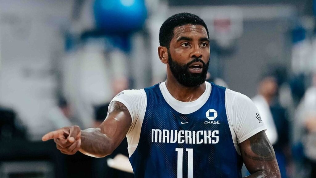 Kyrie Irving points during practice while wearing a blue Dallas Mavericks No. 11 practice jersey.