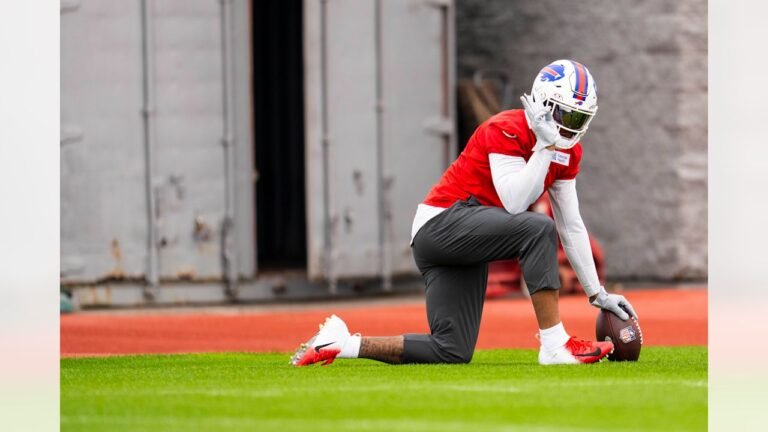 DJ Moore kneels at Buffalo Bills practice in a red jersey.