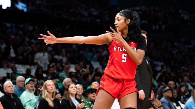 Angel Reese directs teammates in a red Atlanta Dream uniform.