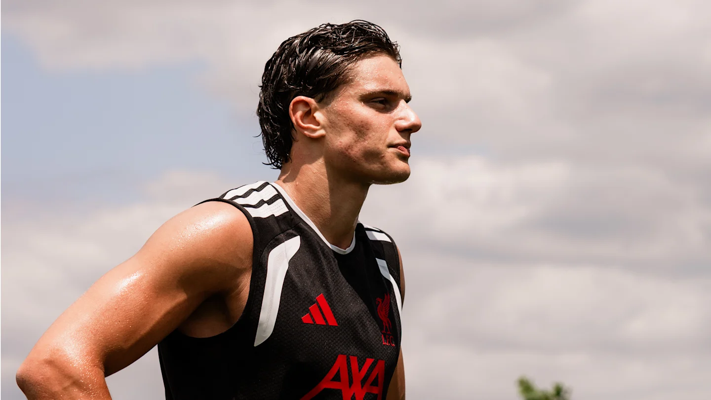 Giovanni Leoni wears a black Liverpool training top outdoors.
