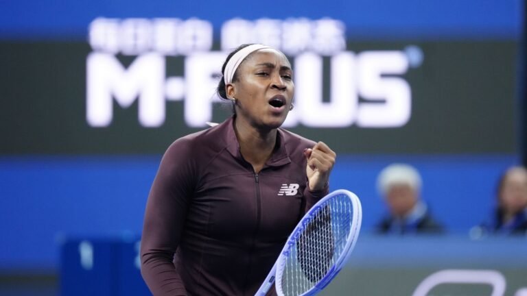 Coco Gauff raises her fist while holding her racket in Beijing.