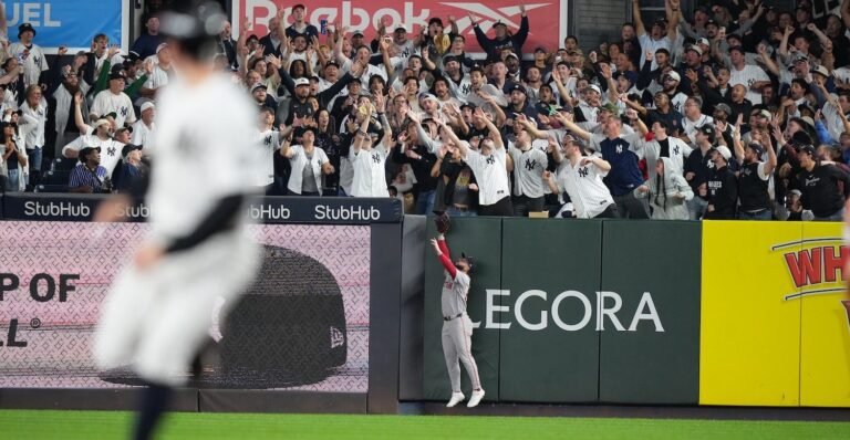 Fans reaching for a baseball in the Yankee Stadium stands during Wild Card Game 2.