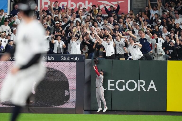 Fans reaching for a baseball in the Yankee Stadium stands during Wild Card Game 2.