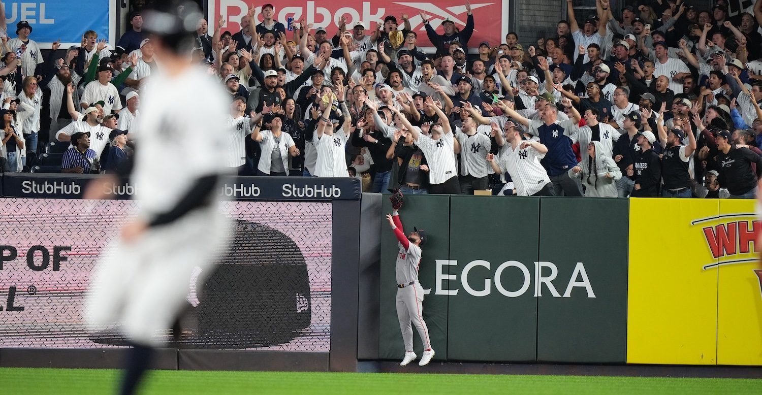 Fans reaching for a baseball in the Yankee Stadium stands during Wild Card Game 2.