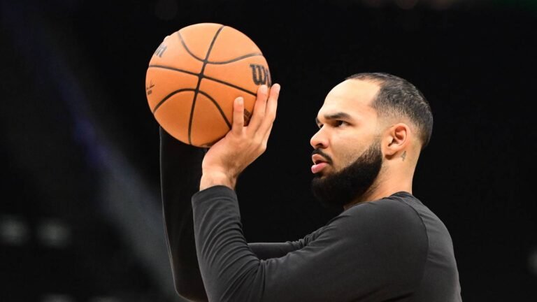 Johni Broome holding a basketball during pregame warmups.