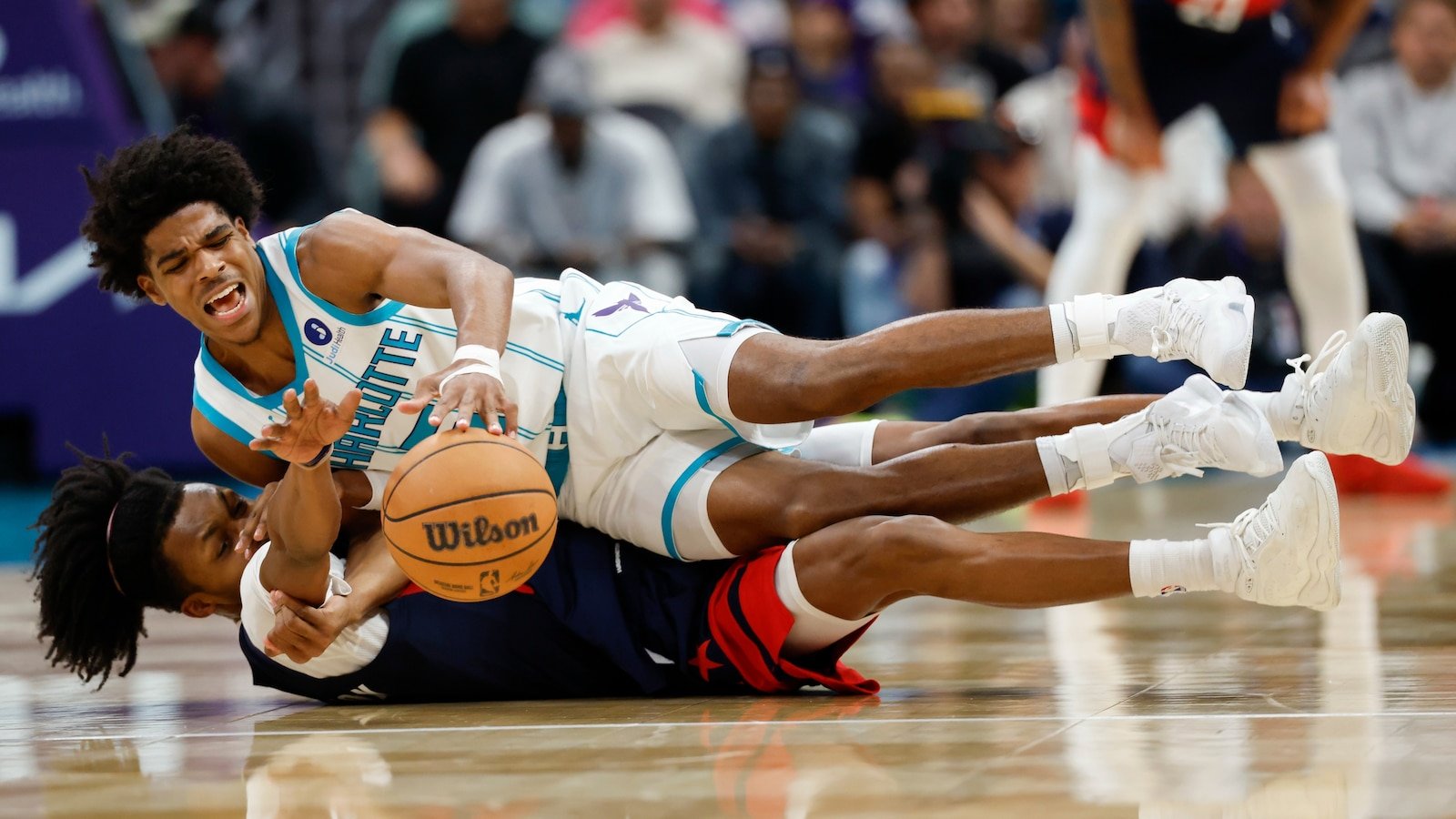 Christian Anderson Jr. and Bub Carrington reaching for a loose ball during Charlotte–Washington on October 26, 2026