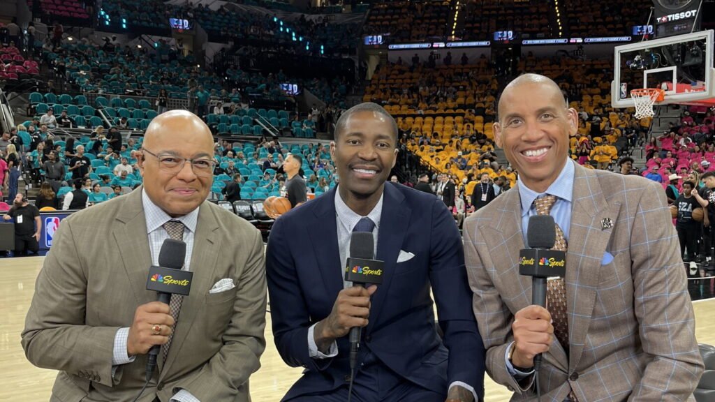 Mike Tirico, Jamal Crawford and Reggie Miller holding NBC Sports microphones at courtside