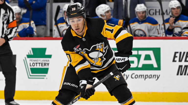 Andrei Kuzmenko skates in a black Penguins jersey and helmet bearing his previous No. 10.