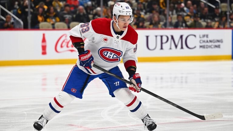 Ivan Demidov carrying his stick while skating in a white Canadiens jersey.