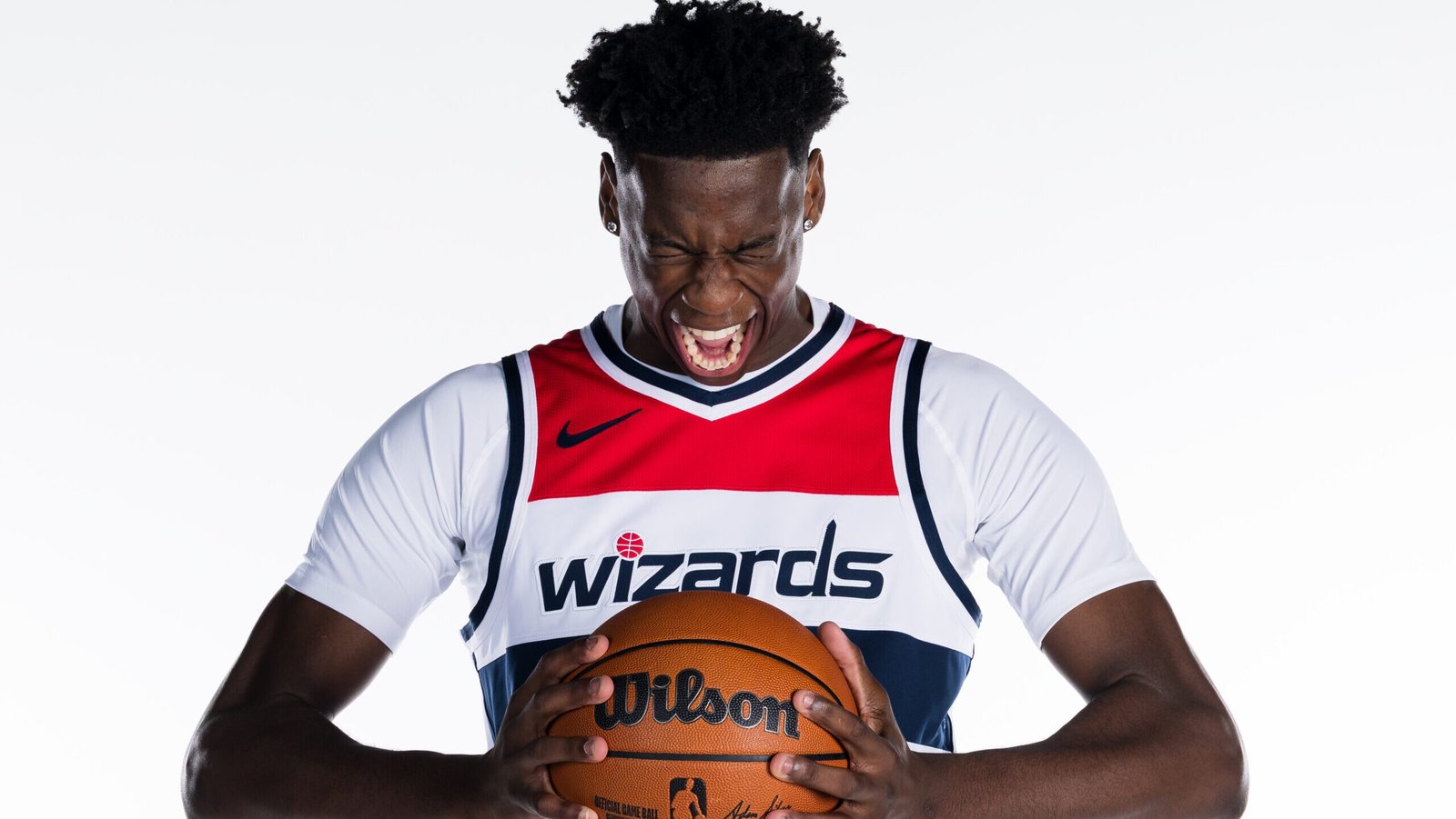 AJ Dybantsa poses while holding a basketball during Wizards Media Day.
